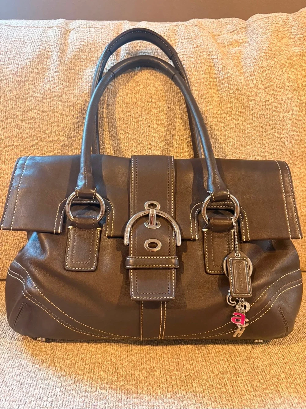 Coach Dark Brown Leather Buckle Satchel with Contrast Stitching.